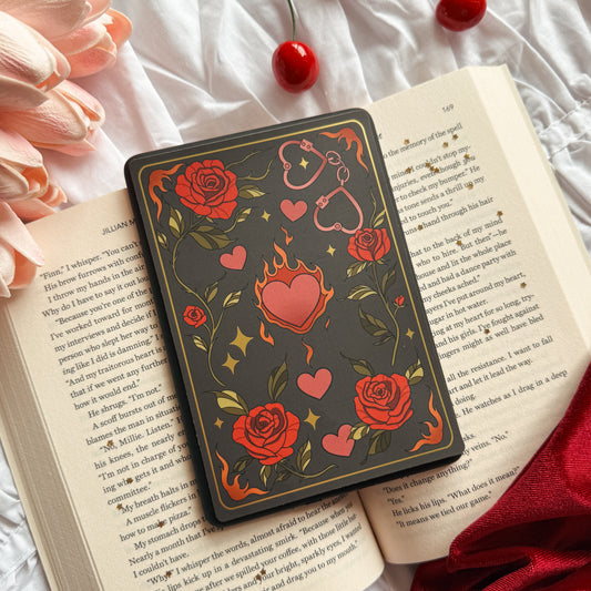 Decorative case with floral and heart designs on an open book with cherries and flowers.